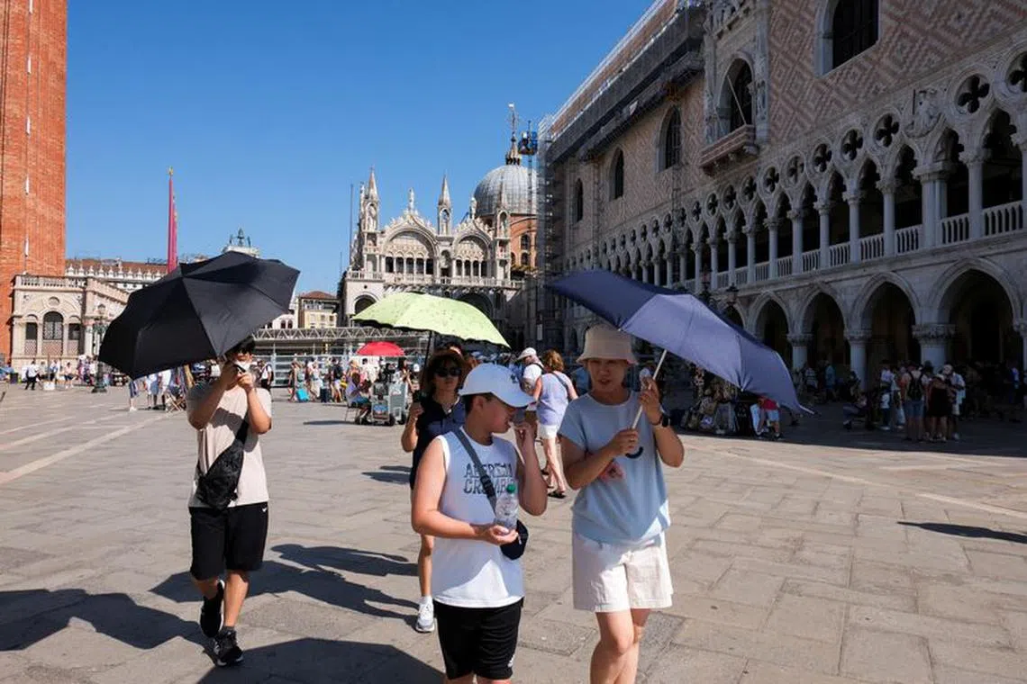 Tourists walk during a new heatwave as temperatures are expected to reach 40 degrees Celsius in some cities, in Venice, Italy August 22, 2023. REUTERS/Manuel Silvestri/File Photo
