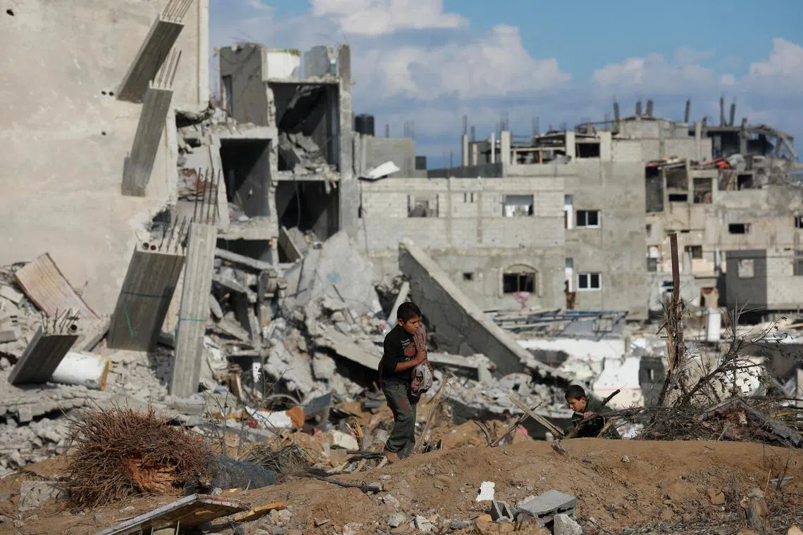 FILE PHOTO: Palestinian children walk near a destroyed building after Israeli forces withdrew from a part of Nuseirat, following a ground operation amid the ongoing conflict between Israel and Hamas, in Nuseirat, central Gaza Strip, November 29, 2024. REUTERS/Abd Elhkeem Khaled