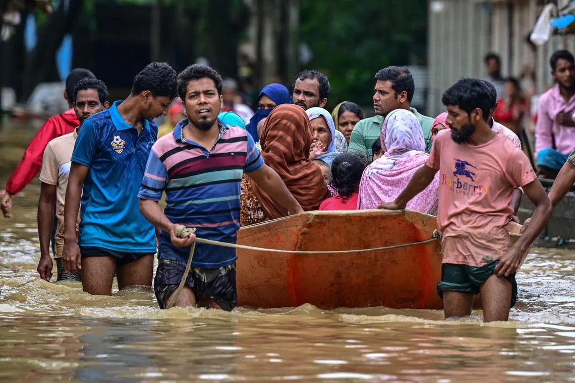 Volunteers rescue flood-affected residents in Feni, in south-eastern Bangladesh, on August 23, 2024. Flash floods wrought havoc in Bangladesh on August 23 as the country recovers from weeks of political upheaval, with the death toll rising to 13 and millions more caught in the deluge. (Photo by MUNIR UZ ZAMAN / AFP)