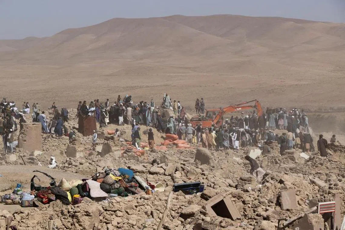 People search for survivors amidst the debris of a house that was destroyed by an earthquake in the district of Zinda Jan, in Herat, Afghanistan, October 8, 2023. REUTERS/Stringer
