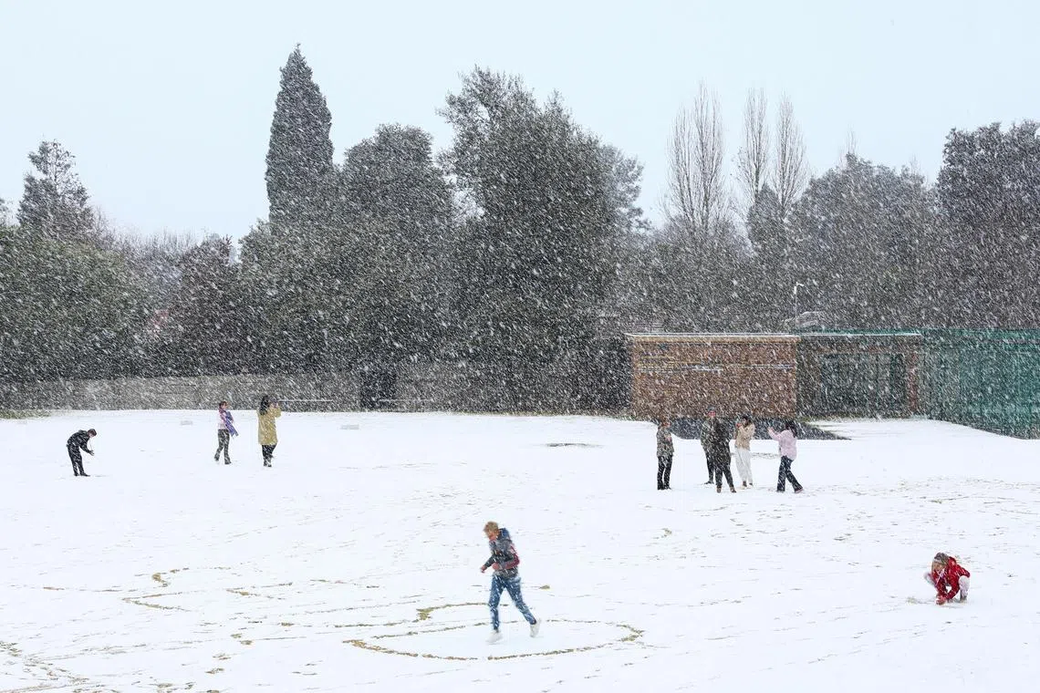 Children play in the snow at Laerskool Orion, Brackenhurst, a suburb south of Johannesburg in South Africa, on July 10.