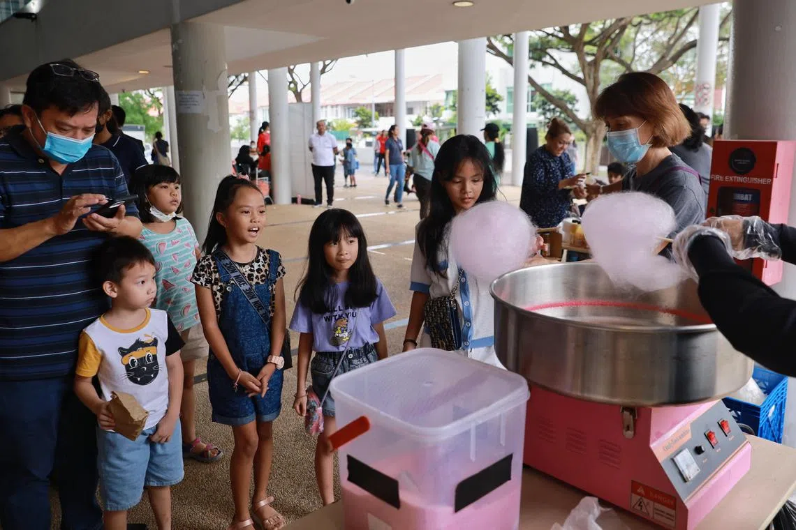 Children queueing for cotton candy at the festive community carnival at Kampong Kembangan CC on Dec 31, 2022.