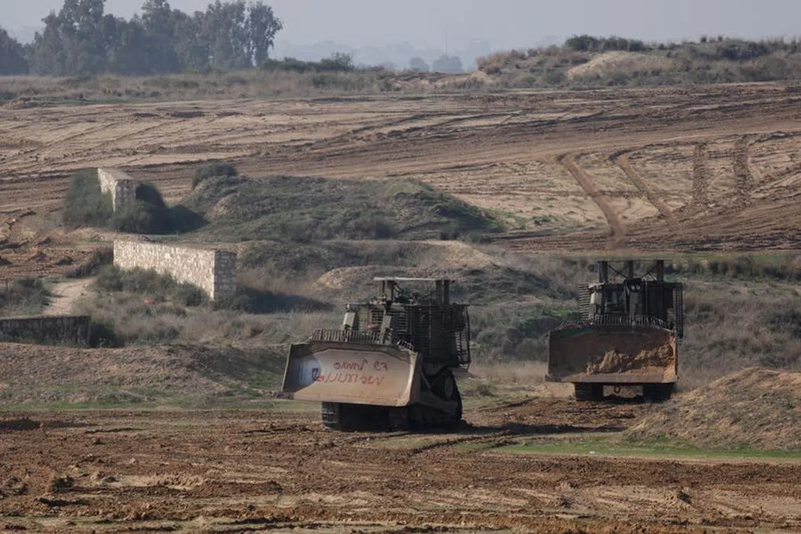 Israeli armoured Caterpillar D9 bulldozers manoeuvre near the border with Gaza , after a temporary truce between Israel and the Palestinian Islamist group Hamas expired, in Israel, December 1, 2023. REUTERS/Amir Cohen