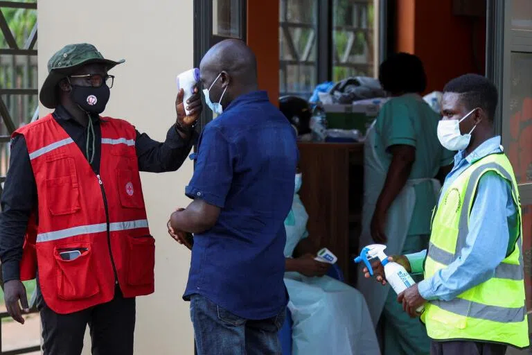 A member of the Uganda Red Cross checking the temperature of a parishioner attending a mass on June 3 at the Basilica of the Uganda Martyr near Kampala, Uganda.