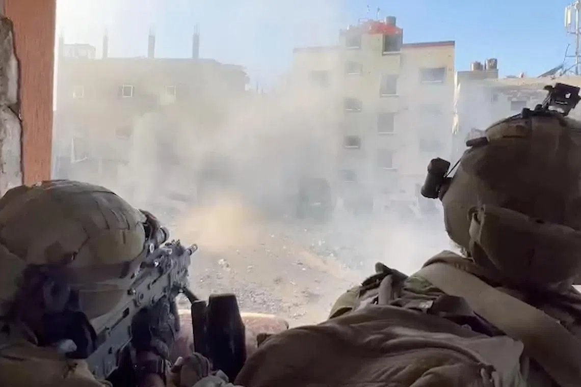 Israeli soldiers fire during the army's ongoing ground operation in Gaza, in a screen grab from a handout video.