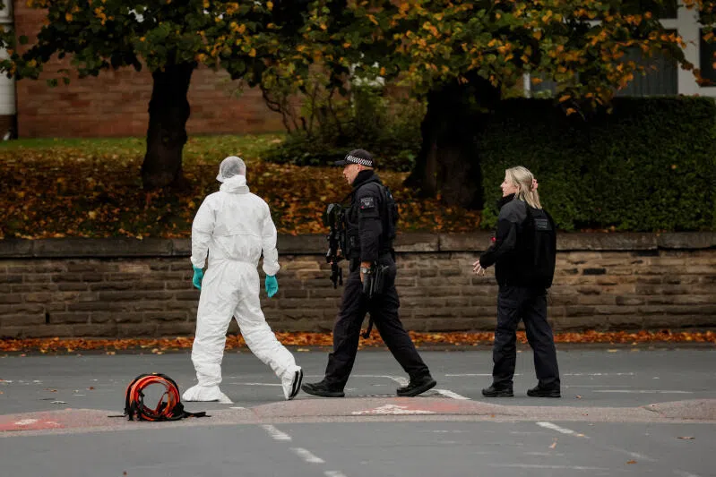 A forensic technician and police officers work at the scene after a man drove a car into pedestrians and stabbed a security guard in an attack at a synagogue in north Manchester, Britain, on Oct 2.