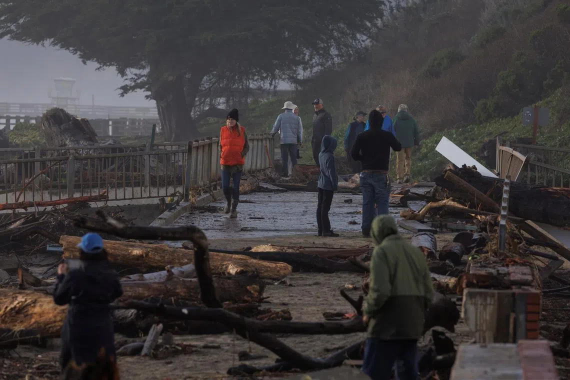 Residents walk in a damaged area after "atmospheric river" rainstorms slammed northern California, in the town of Aptos, U.S., Jan 5, 2023. 