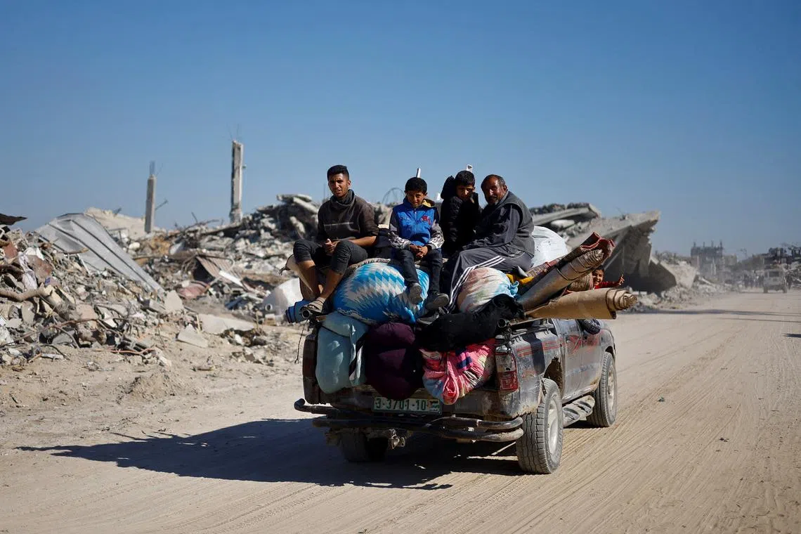 Palestinians ride a vehicle past the rubble of houses and buildings destroyed during the war, following a ceasefire between Israel and Hamas, in Rafah in the southern Gaza Strip, January 21, 2025. REUTERS/Mohammed Salem