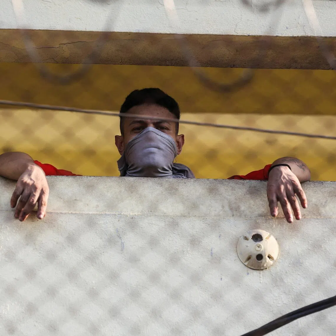 An inmate looks out from a security tower at the Renovacion 1 prison, as inmates at three Guatemalan prisons rioted on Saturday and took mostly prison guards hostage on Jan 17.