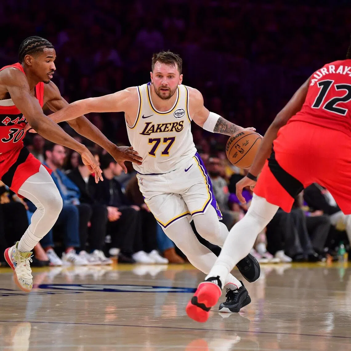 Los Angeles Lakers guard Luka Doncic moves the ball against Toronto Raptors guard Ochai Agbaji and forward Collin Murray-Boyles during the first half at Crypto.com Arena. 