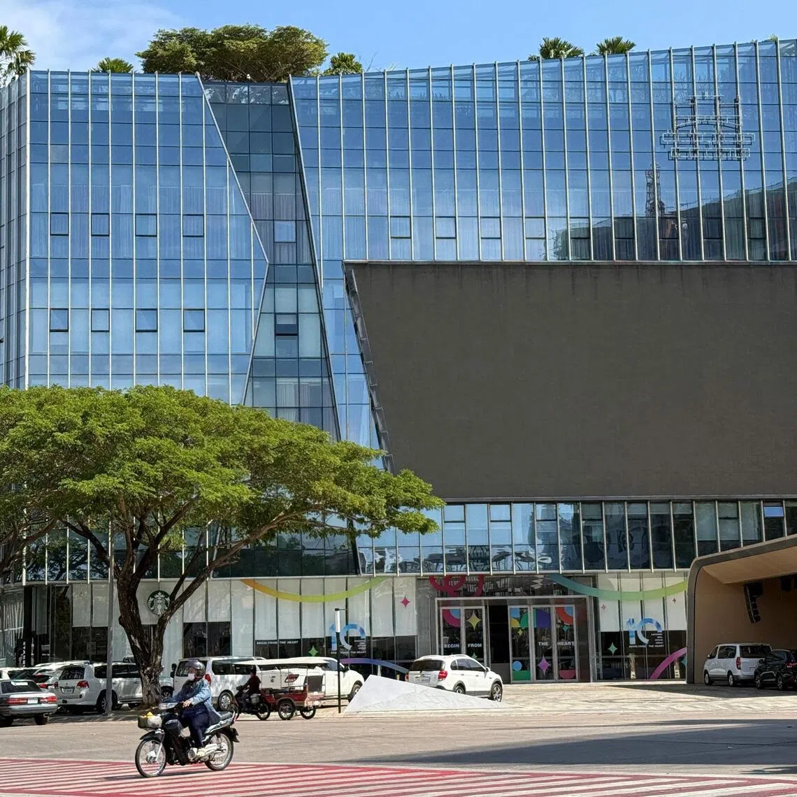 Motorists ride past the Prince Group Headquarters in Phnom Penh.