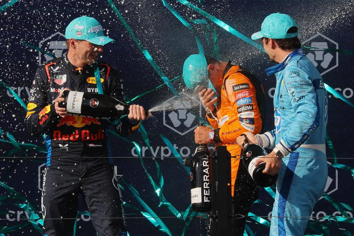 McLaren's Lando Norris celebrating after winning the Miami Grand Prix alongside second placed Red Bull's Max Verstappen and third placed Ferrari's Charles Leclerc.