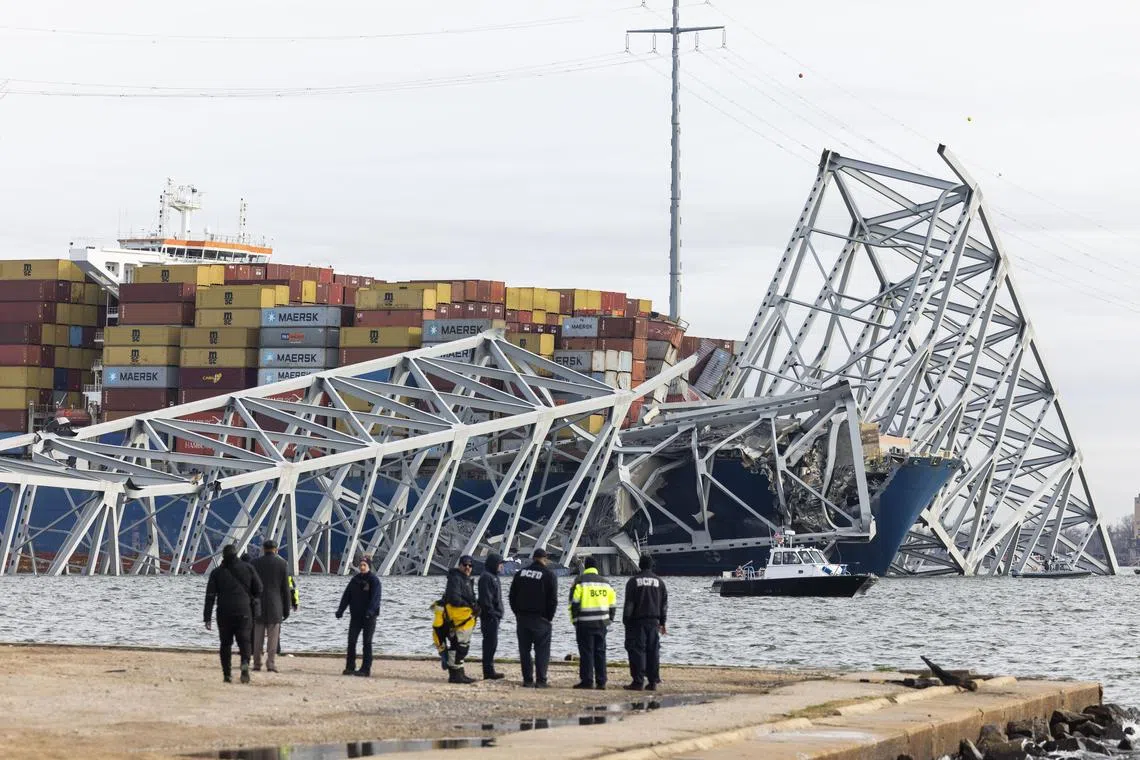 Rescue personnel gather on the shore of the Patapsco River after a container ship ran into the Francis Scott Key Bridge in Baltimore causing its collapse on 26 March.