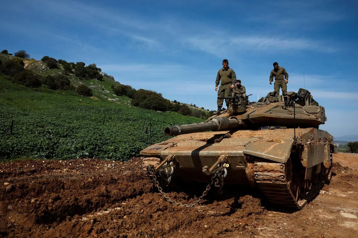 Israeli soldiers stand on a tank on the Israeli side of the border with Lebanon, amid escalation between Hezbollah and Israel, amid the U.S.-Israeli conflict with Iran, in northern Israel, March 6, 2026. REUTERS/Ammar Awad