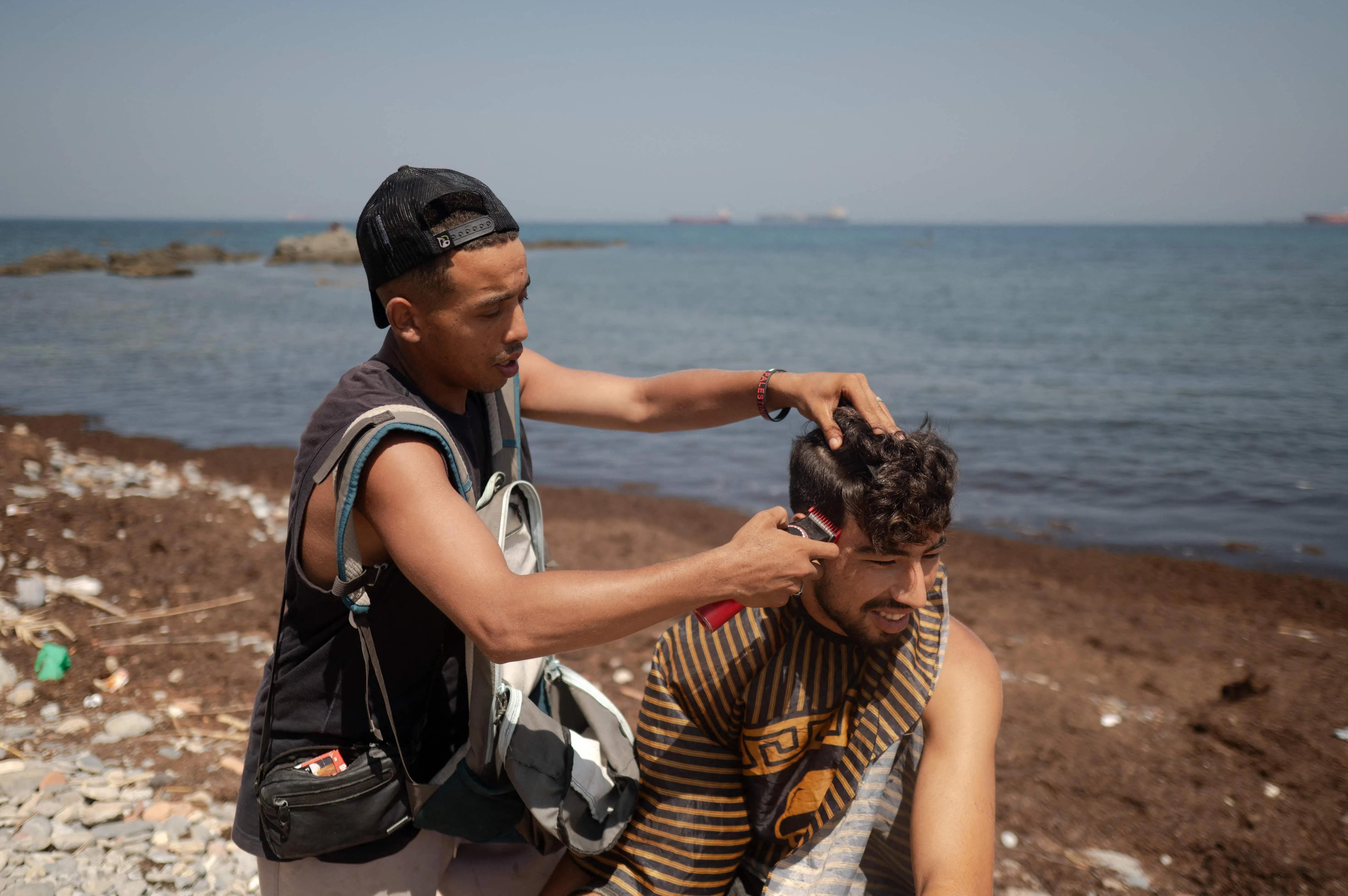 A migrant gets a haircut while waiting to enter a short-stay migrants centre in Ceuta, Spain.