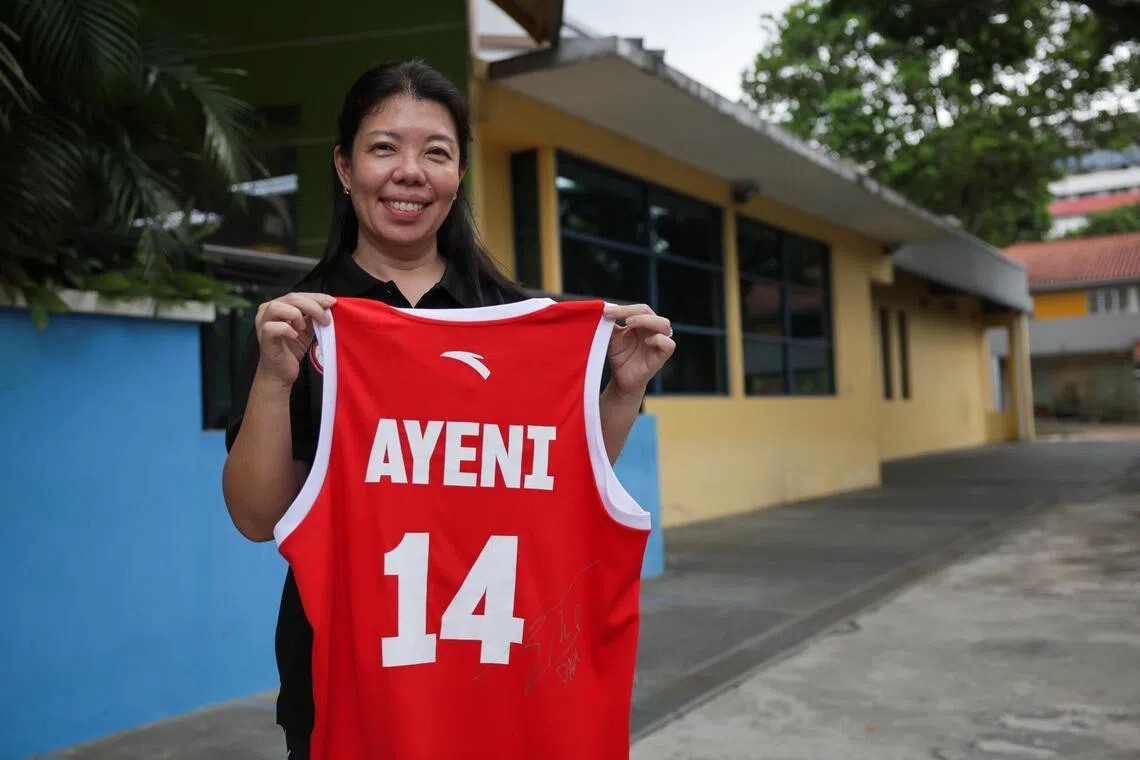 Joyce Lim, Basketball Association of Singapore (BAS) task force co-chair and emcee, holding a Singapore basketball team jersey signed by South Korean singer Sandara Park during a media preview for the BAS fundraising campaign at the Basketball Association of Singapore on July 17, 2026.