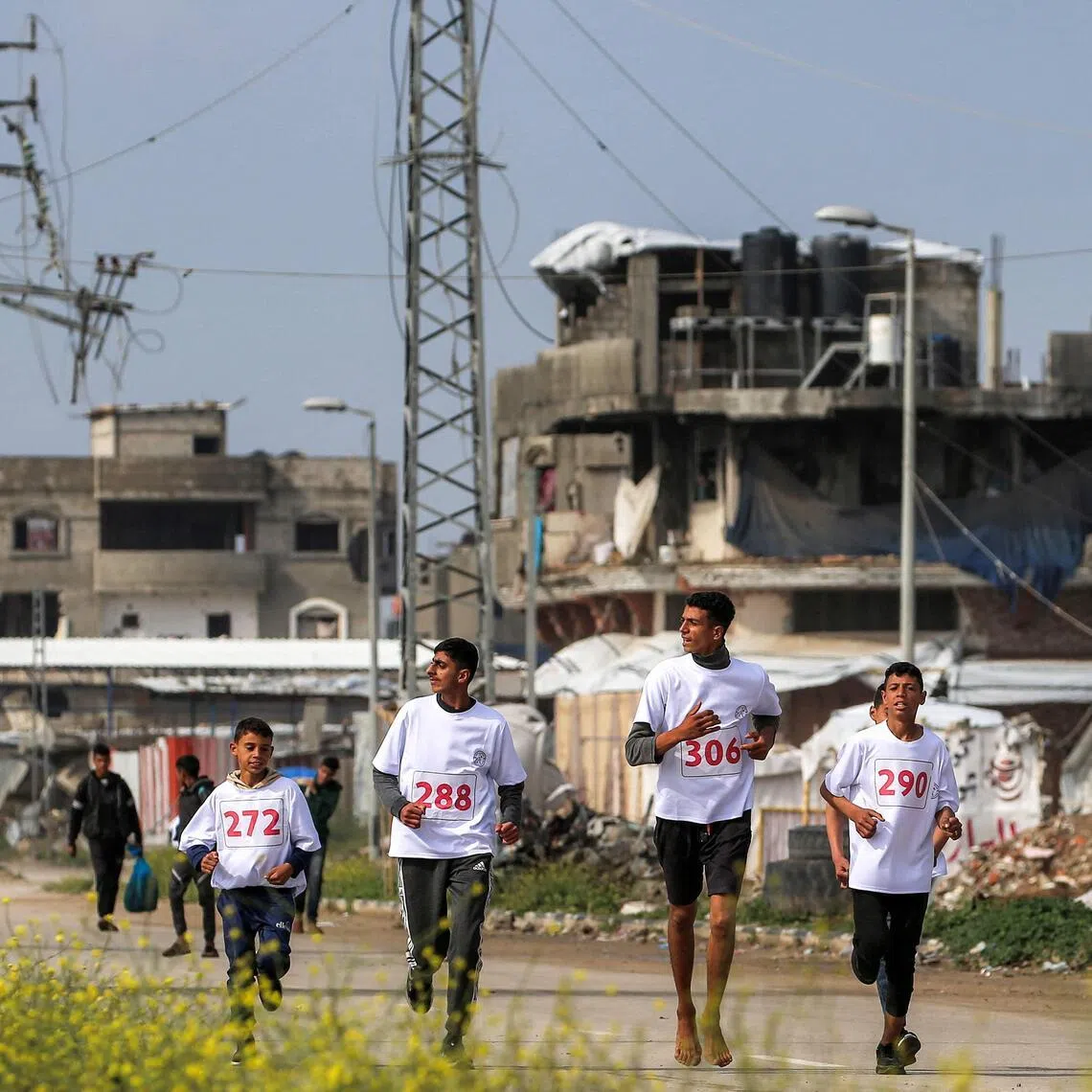 Damaged buildings in the Bureij camp for Palestinian refugees in the central Gaza Strip are seen in this photo from on March 27, 2026. Violence has persisted in Gaza despite a ceasefire in October 2025, though life goes on as shown by these runners who were taking part in a marathon event.