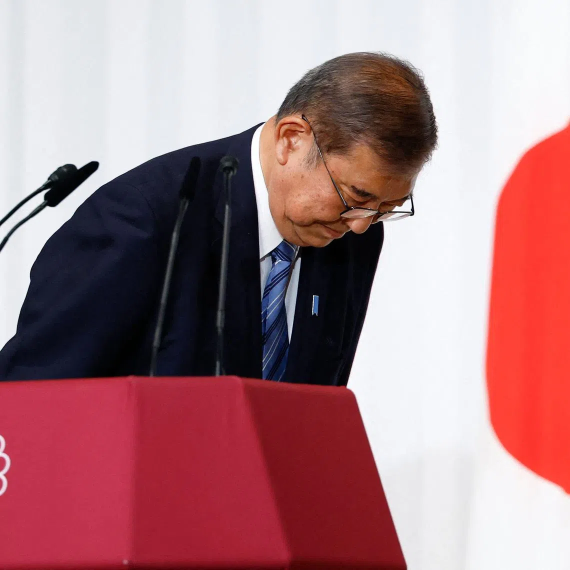 Shigeru Ishiba, Japan's Prime Minister and leader of the ruling Liberal Democratic Party (LDP), bows to LDP lawmakers onstage after a press conference at the party's headquarters in Tokyo on October 28, 2024. Ishiba said on October 28 he will stay in office despite his party losing its majority, saying he would not create a "political vacuum".