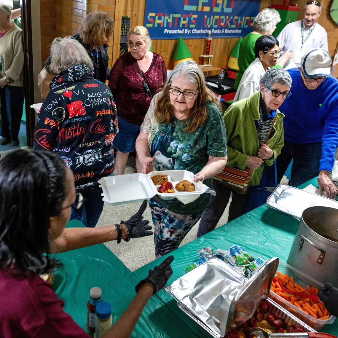 FILE PHOTO: Senior citizens receive a hot meal at the Roosevelt Community Center as food banks across the country, already strained by rising demand, say they will have less food to distribute because of federal funding cuts and pauses by the Trump administration, in Charleston, West Virginia, U.S., March 19, 2025. REUTERS/Evelyn Hockstein/File Photo