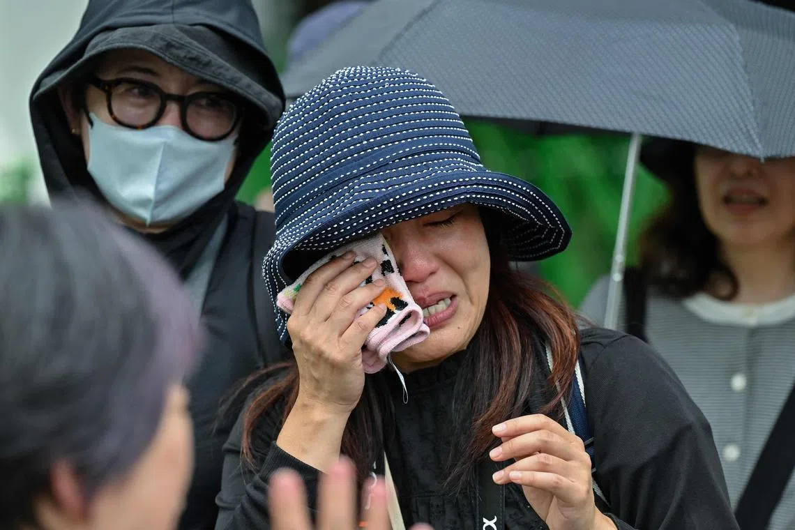 A woman reacts after visiting the panda enclosure on the last day of viewing before they are are sent back to China after 13 years, at Tokyo’s Ueno Zoo on September 28, 2024. Thousands of thankful, sobbing fans flocked to Tokyo Ueno Zoo on September 28 to bid an emotional farewell to the pair of beloved, ageing pandas before their imminent return to China. (Photo by Richard A. Brooks / AFP)