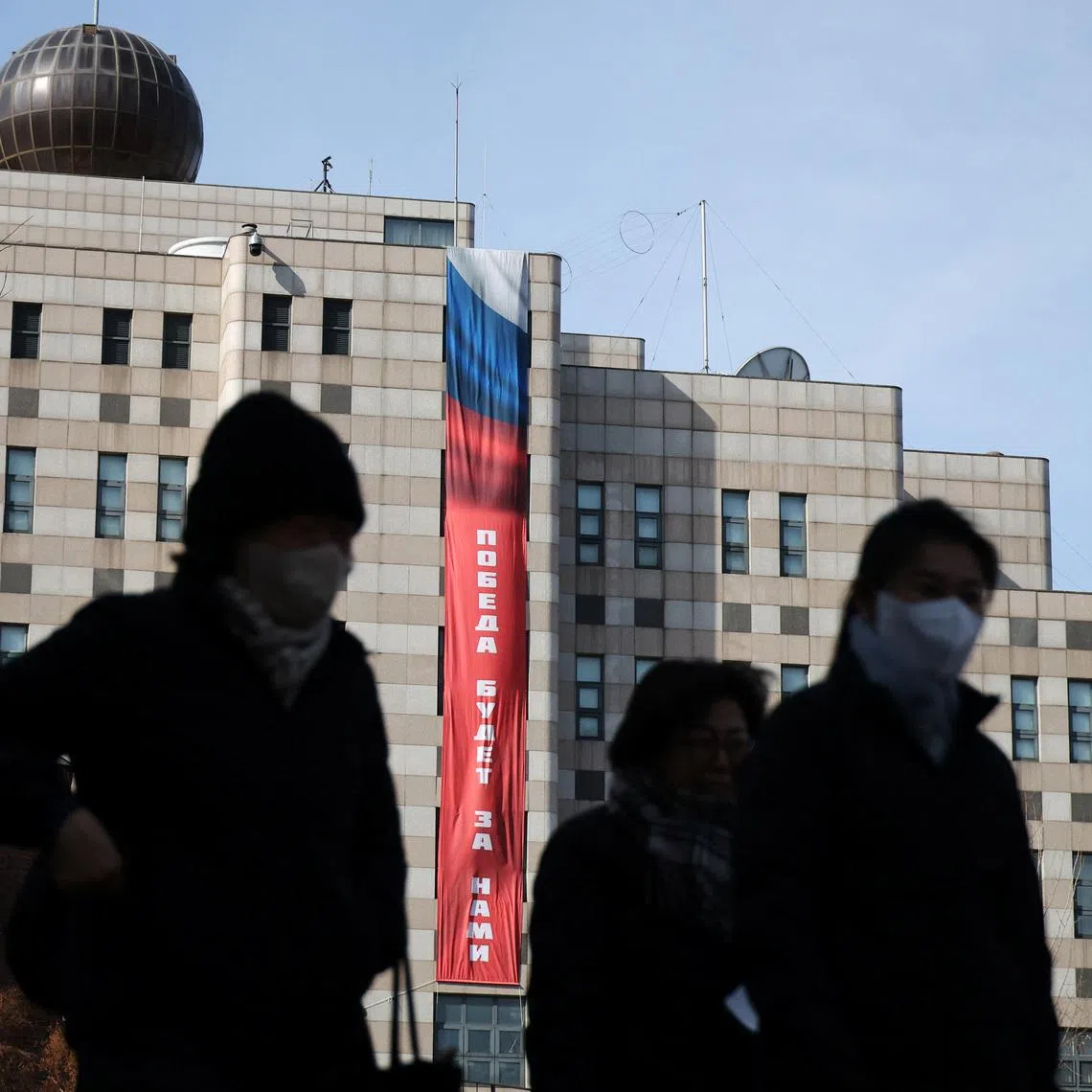 People walk past a banner that reads \"Victory will be ours,\" hanging on the exterior of the Russian Embassy, ahead of the fourth anniversary of Russia’s invasion of Ukraine, in Seoul, South Korea, February 23, 2026. REUTERS/Kim Hong-Ji