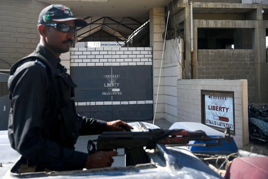 A Pakistani policeman stands guard outside a factory where two Chinese nationals were allegedly shot, in Karachi on Nov 5.
