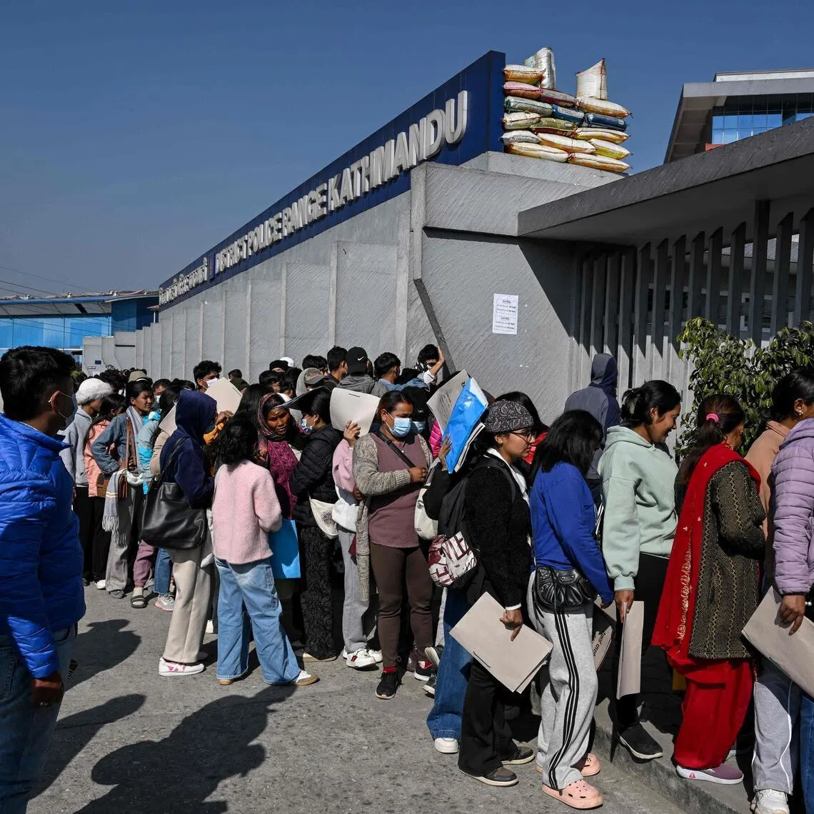 Nepalis queueing to submit applications for temporary jobs policing upcoming elections in Kathmandu on Jan 11.