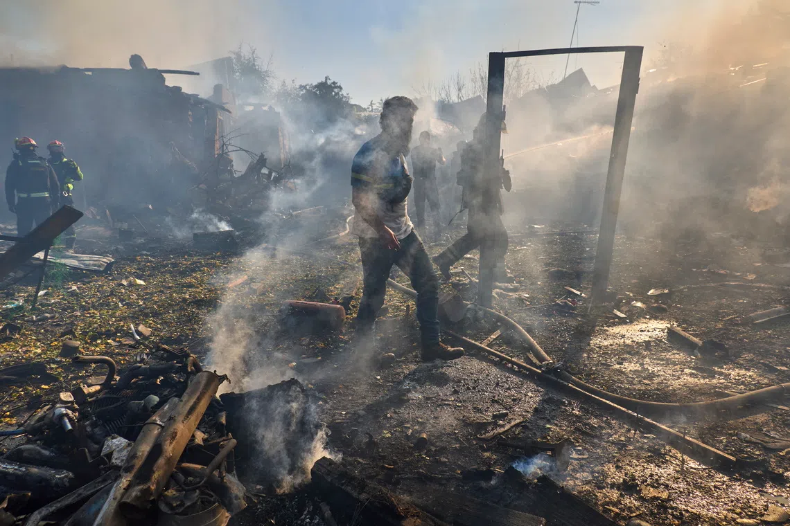 Ukrainian rescuers work at the site of a Russian air strike on a residential area in Kharkiv, north-eastern Ukraine, on Oct 11.