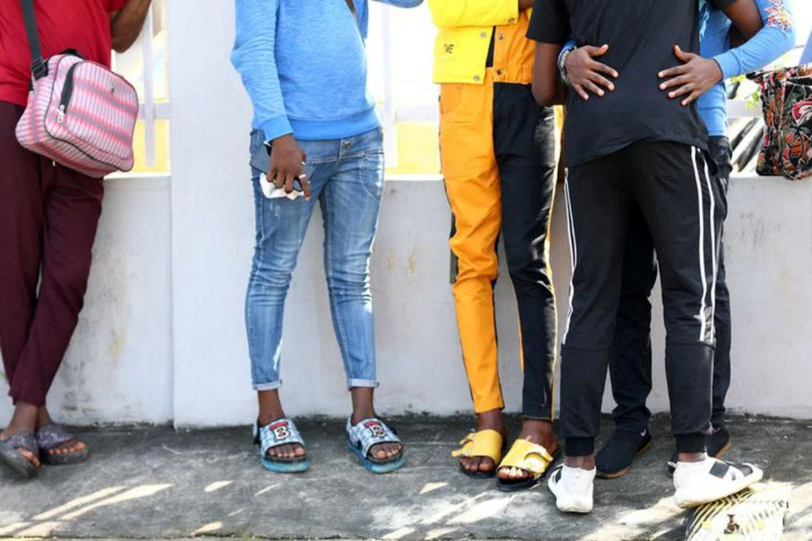 FILE PHOTO: Some of the men charged with public displays of affection with members of the same sex are seen gathered outside a court in Lagos, Nigeria October 27, 2020. REUTERS/Temilade Adelaja/File Photo