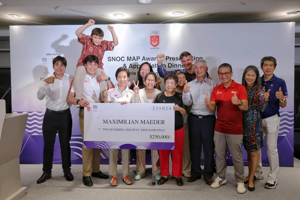Kitefoiler Maximilian Maeder (second from left) collecting $250,000 for his Olympic bronze medal in kitefoiling from Minister for Sustainability and the Environment Grace Fu (fourth from left), Minister for Culture, Community and Youth Edwin Tong (third from right) and Ms Tan Su-Yin (fifth from left), director, Grants, Tote Board, at the Major Games Awards Programme (MAP) Presentation and Appreciation Dinner for the Paris 2024 Olympic Games at Skai Suites in Swissotel The Stamford on Oct 23, 2024. Joining Max are (from left) his younger brother Karl, youngest brother Valentin Jr (sitting on Max's shoulder), cousin Teng Rou Rui, grandmother Tan Ah Moy, mother Hwee Keng, father Valentin, grandfather Teng Lay An, aunt Patricia Yeo (Rou Rui's mother), and uncle Teng Chuan Hiang (Rou Rui's father and Hwee Keng's elder brother). ST PHOTO: KEVIN LIM dlmap23