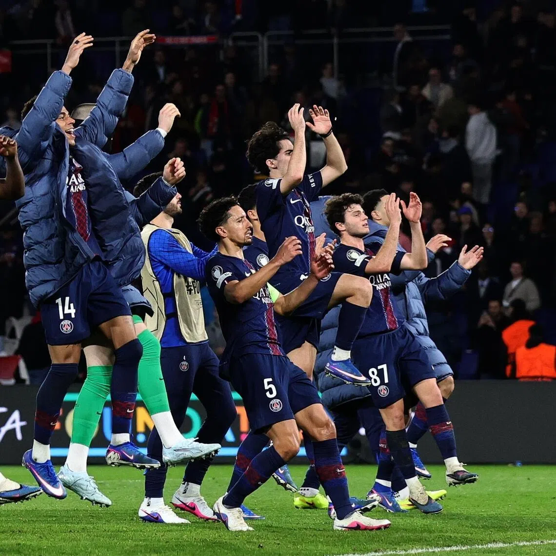 Paris Saint Germain players celebrate edging into the Champions League’s last 16 after a 2-2 home draw.