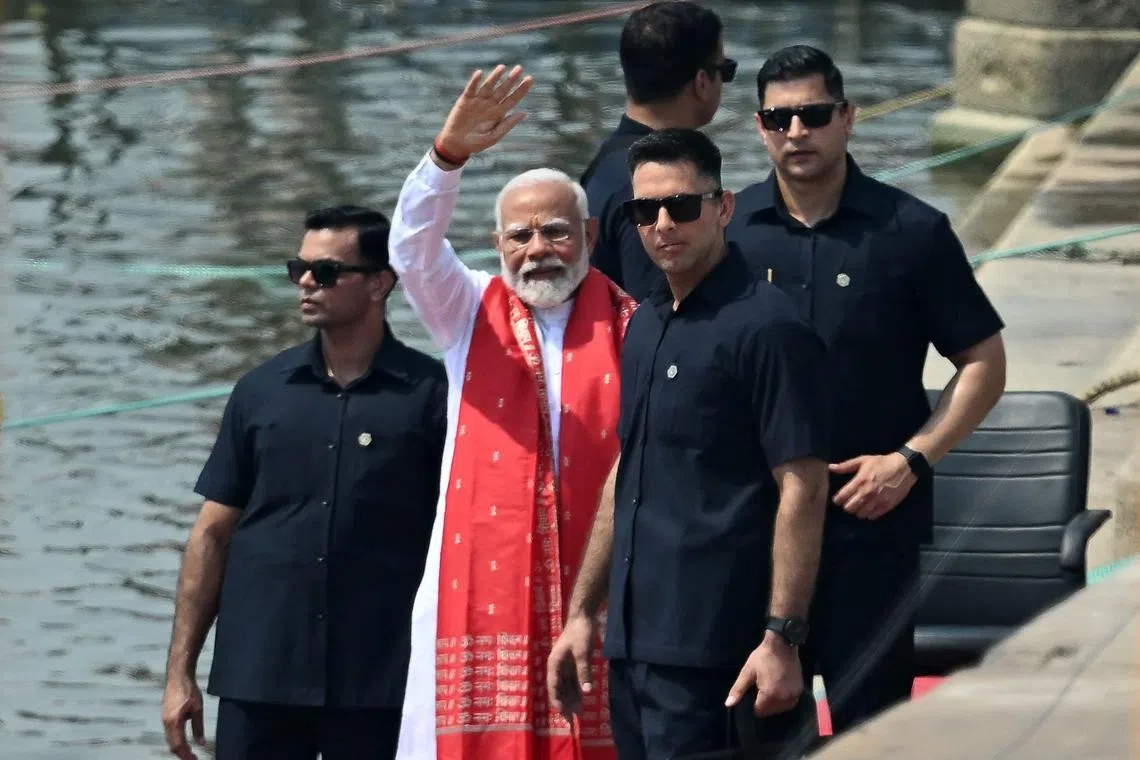 Mr Modi (centre) waves after offering prayers on the banks of the Ganges River in Varanasi on May 14.