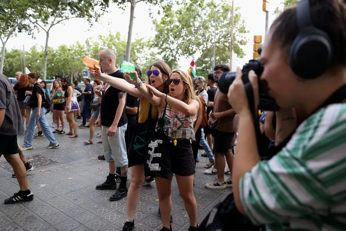 FILE PHOTO: Protesters shoot water from water guns at tourists during a protest against mass tourism in Barcelona, Spain, July 6, 2024. REUTERS/Bruna Casas/File Photo
