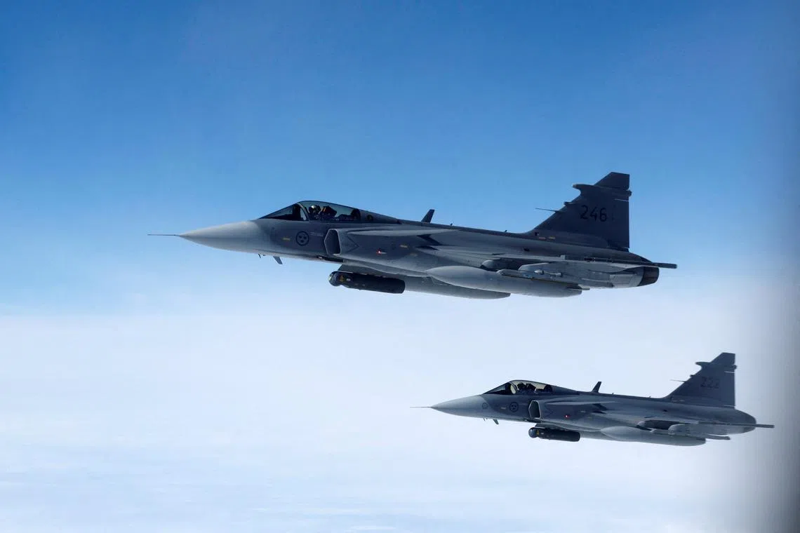 FILE PHOTO: Swedish Air Force Saab JAS 39 Gripen fighter jets fly alongside an aircraft simulating aerial interceptions, during a media day illustrating how NATO Air Policing safeguards the Allies' airspace in the northern and northeastern region of the Alliance, July 4, 2023. REUTERS/Piroschka van de Wouw/File Photo