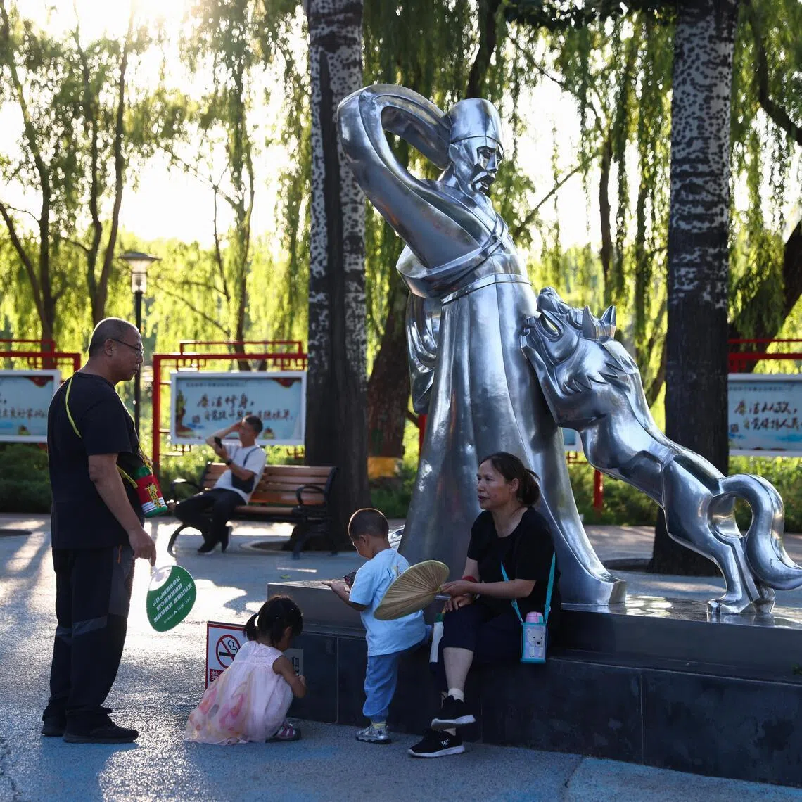 People play with children in a park in Beijing, China.