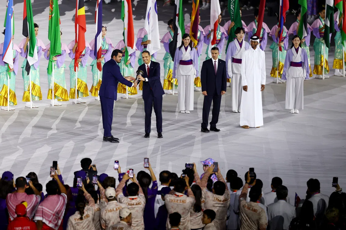 Asian Games - Aichi-Nagoya 2026 - Closing Ceremony - Paloma Mizuho Stadium, Nagoya, Japan - October 4, 2026 OCA president Sheikh Joaan bin Hamad Al Thani passes on the torch of the first Asian Games to Qatar's Prime Minister Sheikh Mohammed bin Abdulrahman Al Thani during the closing ceremony REUTERS/Edgar Su