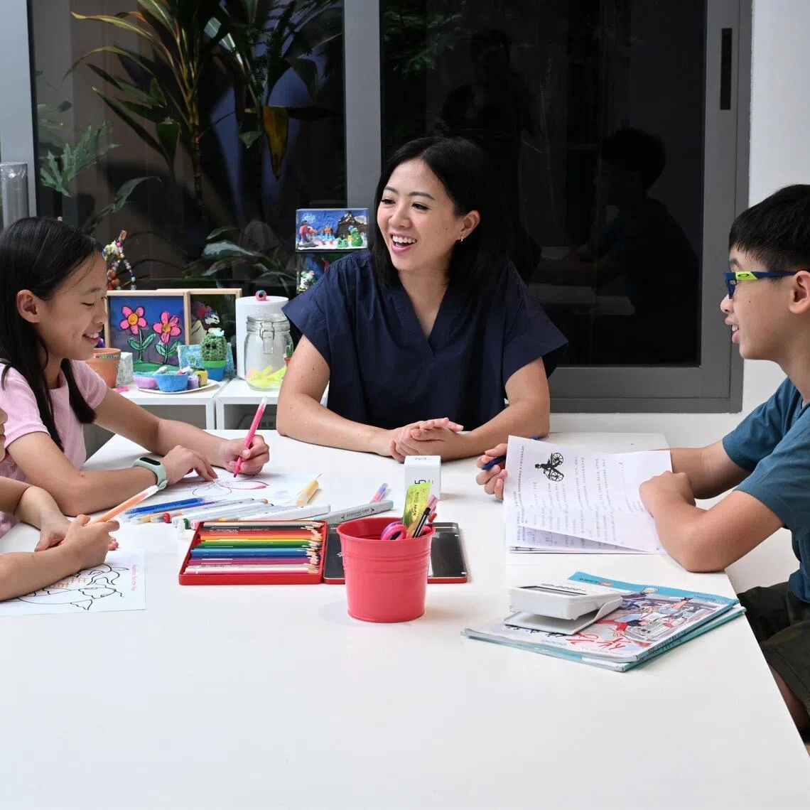 Ms Fynn Sor, 43, with her children (from left) Abby Wong, seven, Riley Wong, 11, and Zachary Wong, 13, at their study corner.
