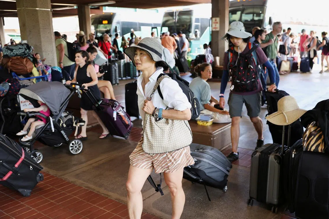 Evacuees from the West Maui wildfires walk at the Kahului Airport on Aug 10.