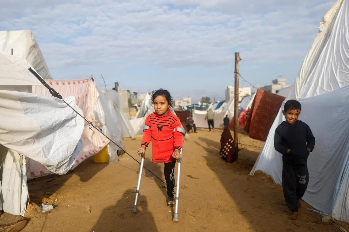 Displaced Palestinian children, who fled their homes due to Israeli strikes, shelter at a tent camp in Rafah, in the southern Gaza Strip.