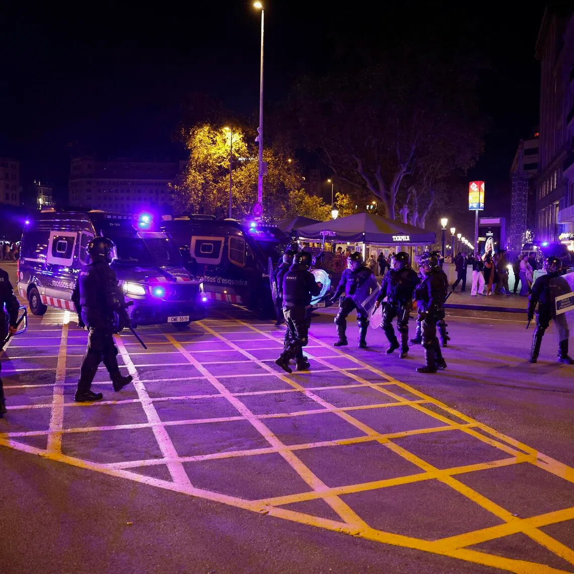 Riot police stand guard during a student-organised protest at Plaza Catalunya in Barcelona, Spain, on Oct 24.