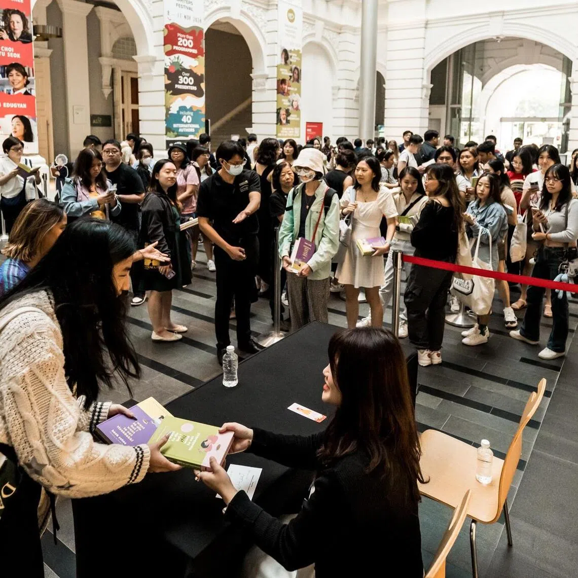 South Korean author Baek Se-hee (seated) autographing her books at the Singapore Writers Festival (SWF) 2024.