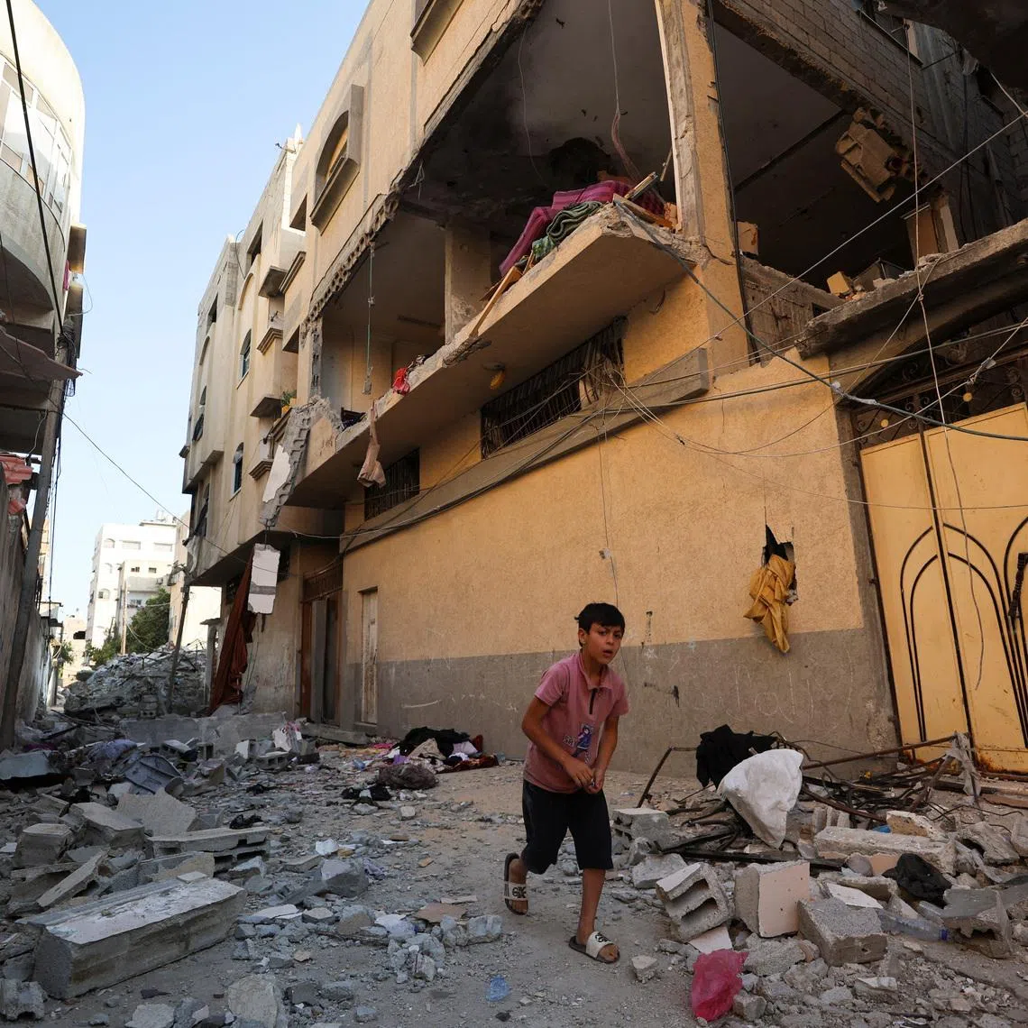 A Palestinian boy runs past the site of an Israeli strike on an apartment in Gaza City, June 20, 2026. REUTERS/Dawoud Abu Alkas