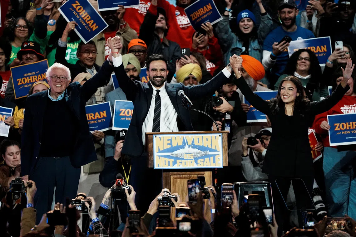 New York City mayoral candidate Zohran Mamdani, U.S. Senator Bernie Sanders (I-VT) and U.S. Representative Alexandria Ocasio-Cortez (D-NY) react on stage during a \"New York is Not For Sale\" rally at Forest Hills Stadium, in the Queens borough of New York City, U.S., October 26, 2025. REUTERS/Eduardo Munoz