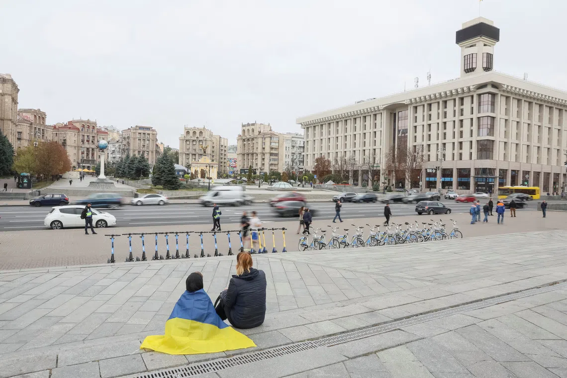 People sit at the Independence Square, as they mark the Defenders of Ukraine Day, amid Russia's attack on Ukraine, in Kyiv, Ukraine October 1, 2024. REUTERS/Gleb Garanich