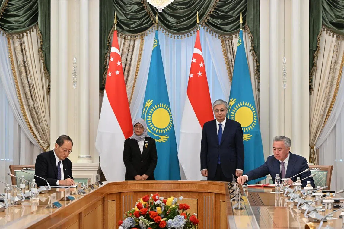 Slug: mnkazakh22
ST PHOTO: Chong Jun Liang

Dr Tan See Leng, Minister for Manpower & Second Minister for Trade and Industry ( far left) signs the services and investment agreement with Kazakhstan Deputy Prime Minister and Minister for Trade and Integration Serik Zhumamgarin (far right) as they are joined by 
Kazakhstan President Kassym-Jomart Tokayev and President Halimah Yacob ( both standing) at the Akorda Palace on May 22, 2023. 

*****
President Halimah Yacob's state visit to Astana, Kazakhstan.