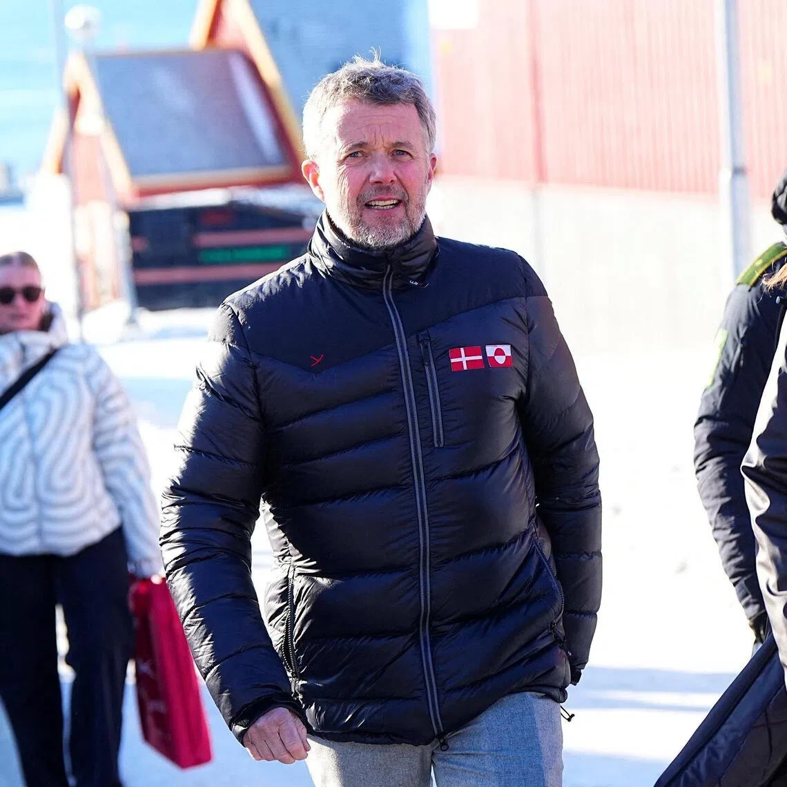 Denmark's King Frederik visiting Nuuk, Greenland, on Feb 18, wearing a black customised puffer jacket featuring the Danish and Greenlandic flag.