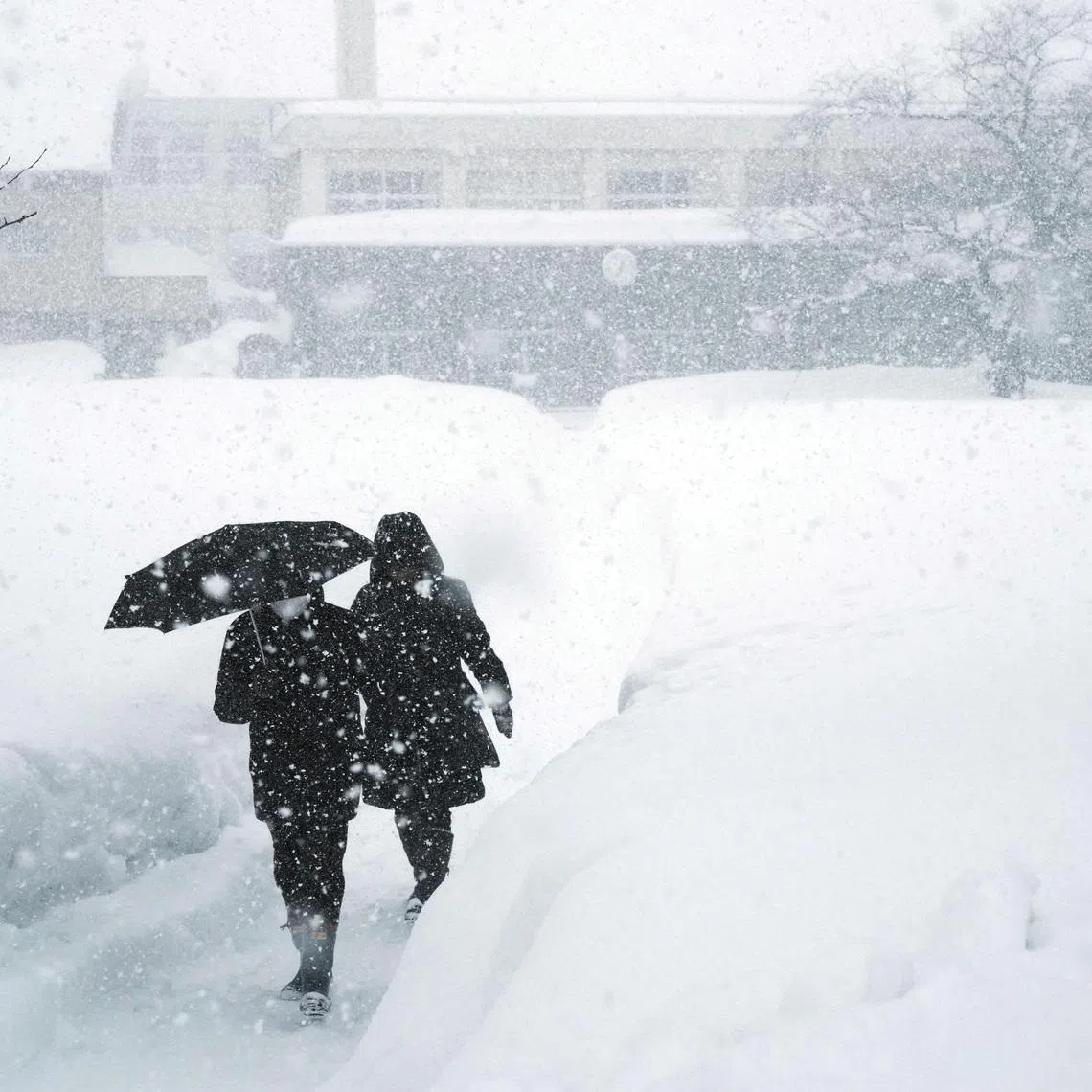 Residents leaving a polling station for Japan's general election in Aomori prefecture on Feb 8. Continued snowfall since late January has buried northern communities and caused traffic chaos.