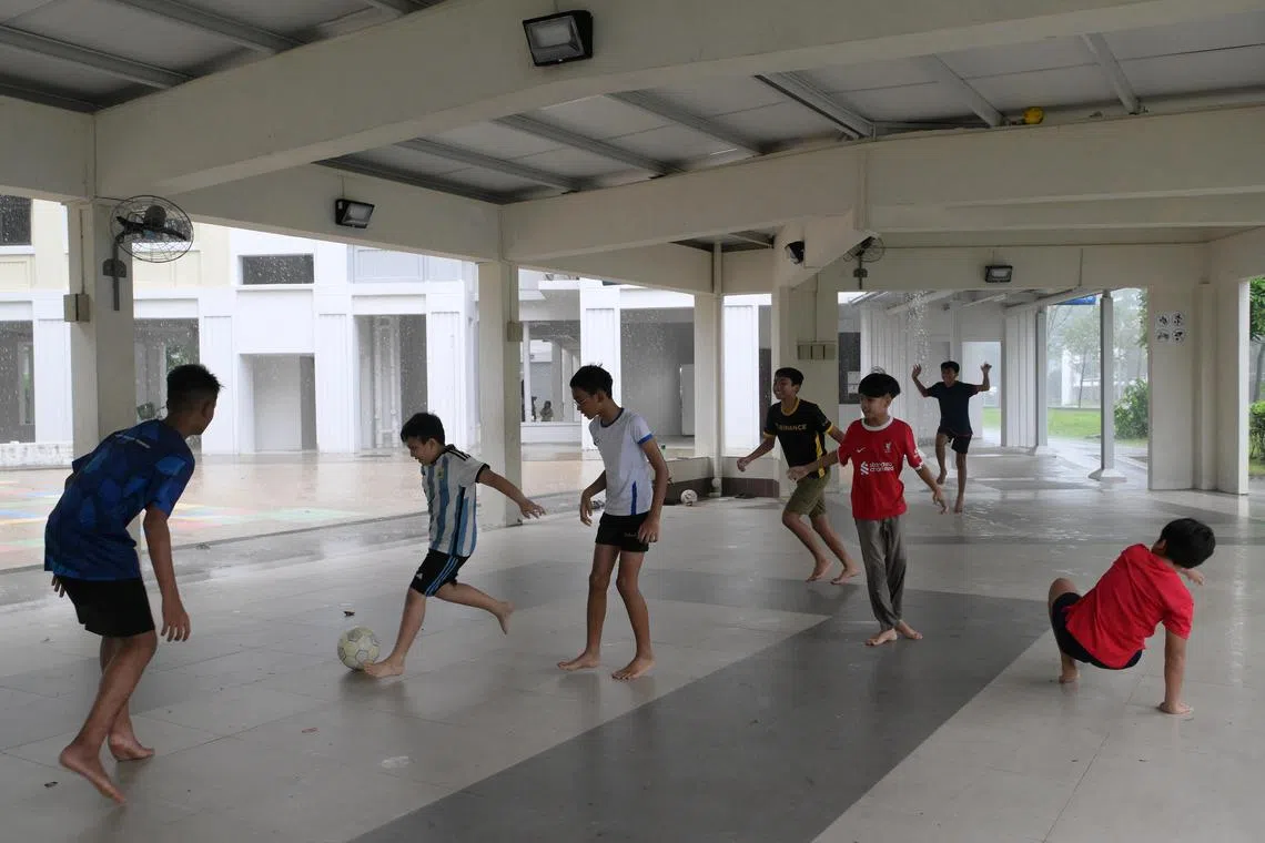 Children playing football at Blk 638A Woodlands Ring Road in Dec 2023, next to the block that had its void deck barricaded following noise complaints from residents. 