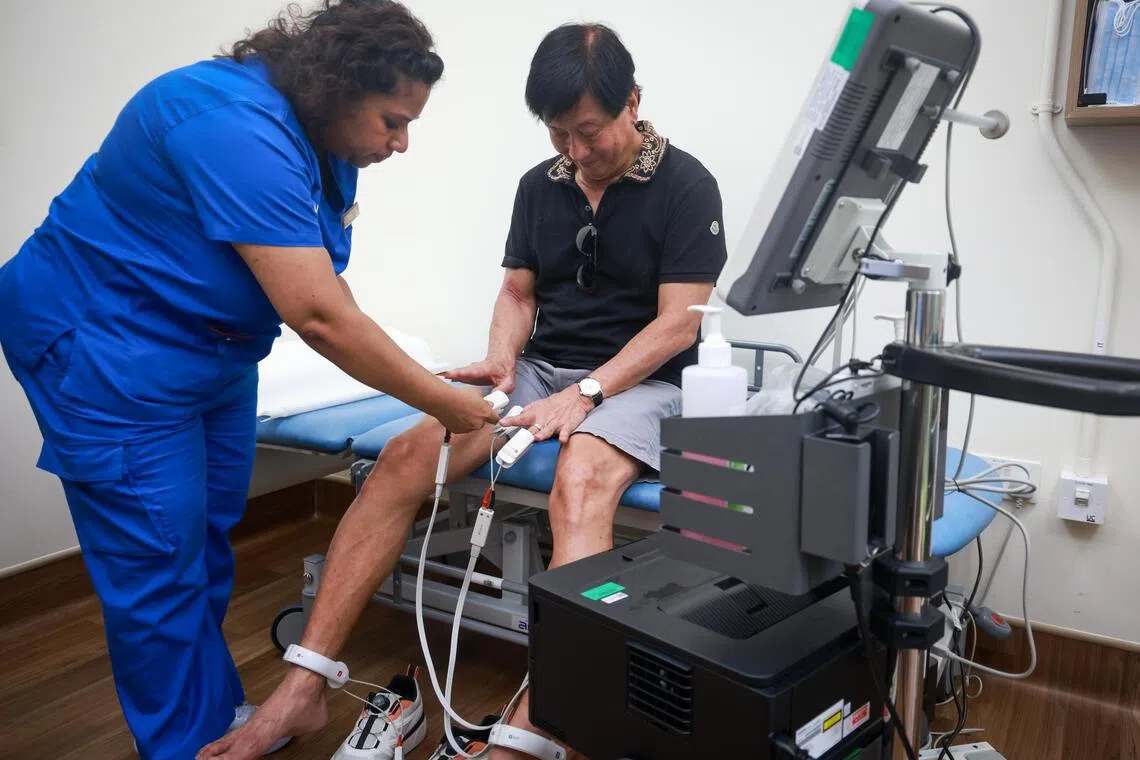 Mr Ivan Low preparing for a Bioelectrical Impedance Analysis test, administered by senior staff nurse Eswari Sundrasagaran at Alexandra Hospital on April 28.