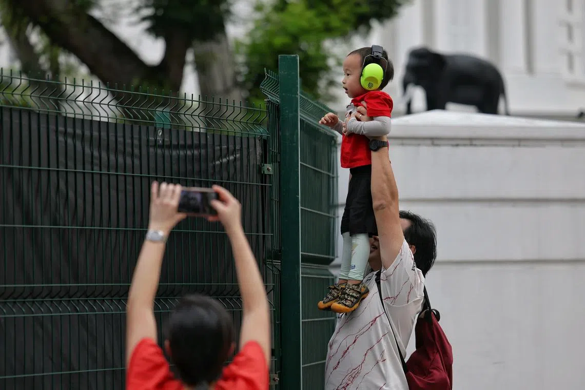 With some help from his father Nan Goh, a 42-year-old entrepreneur, Joshua Wu, three, catching a glimpse of practice 1 of at the Singapore Airlines Singapore Grand Prix, Marina Bay street circuit on September 20, 2024. 